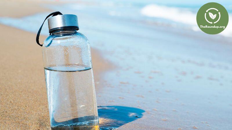 glass water bottle on beach